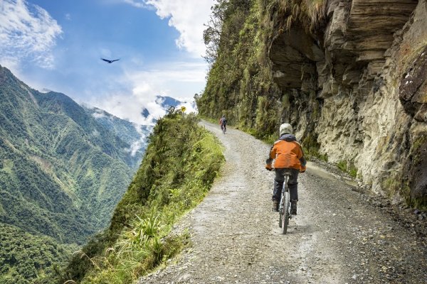 Bike tourists riding on the "road of death" downhill track, Bolivia Bike tourists riding on the "road of death" downhill track, Bolivia