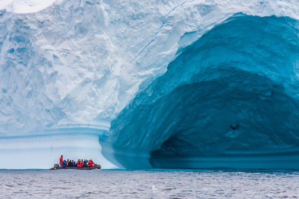 Zodiac in front of enormous ice berg in Antarctica Zodiac in front of enormous ice berg in Antarctica