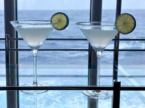 Cocktails on Le Soleal Two cocktail drinks on a glass table, with view of ocean behind them